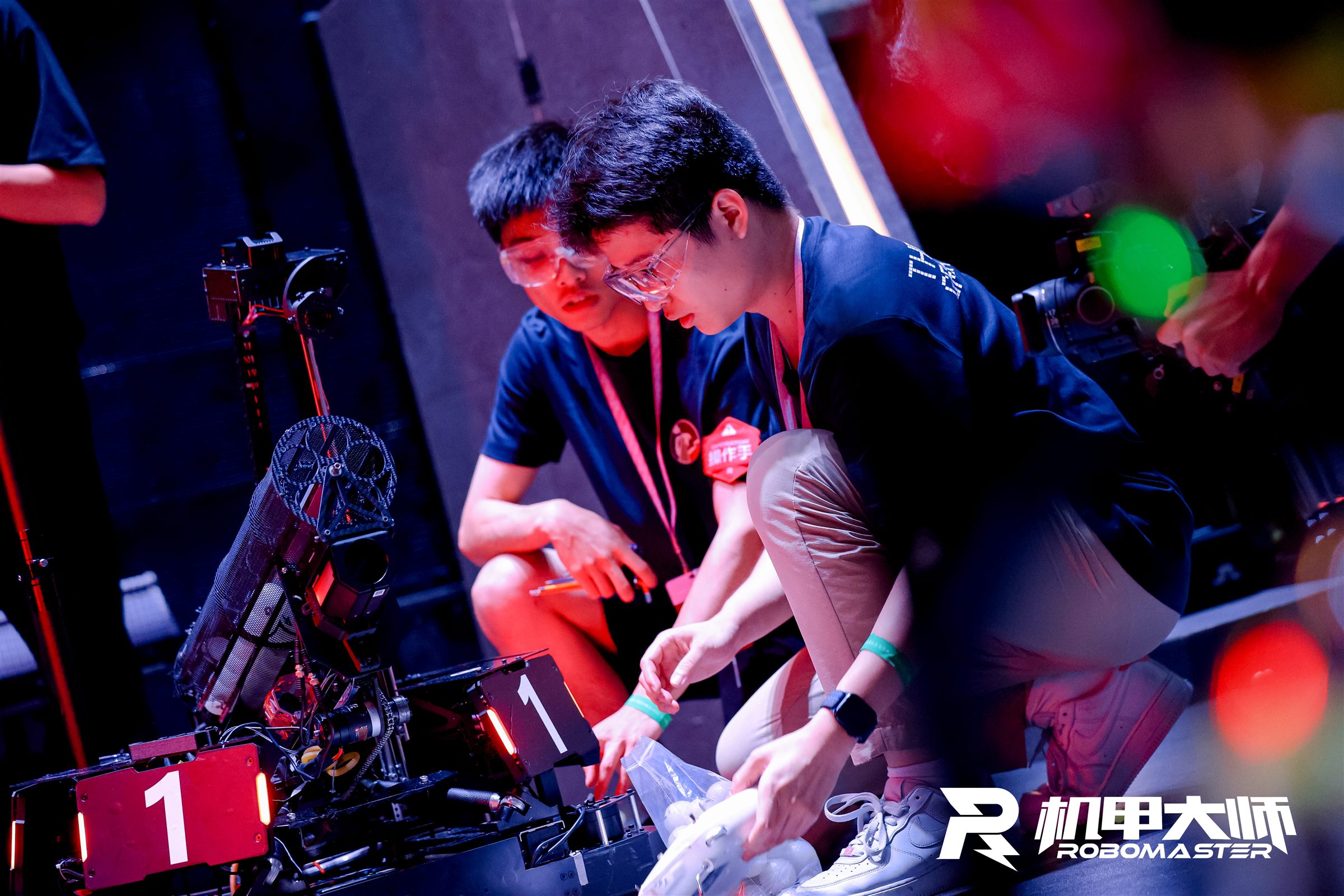 Two team members loading projectiles into the hero robot before a match